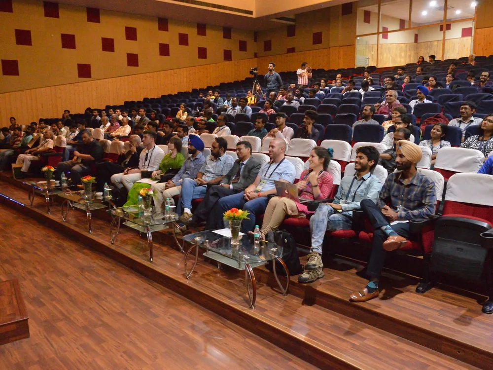 A full audience seated and watching a keynote session at a conference